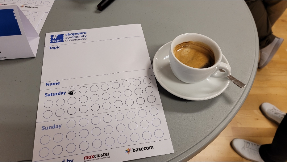 A coffee, pen and paper on a table.