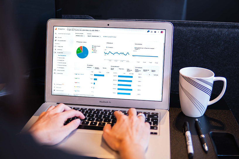 Person working on laptop with Google Analytics – focus on website data analysis.