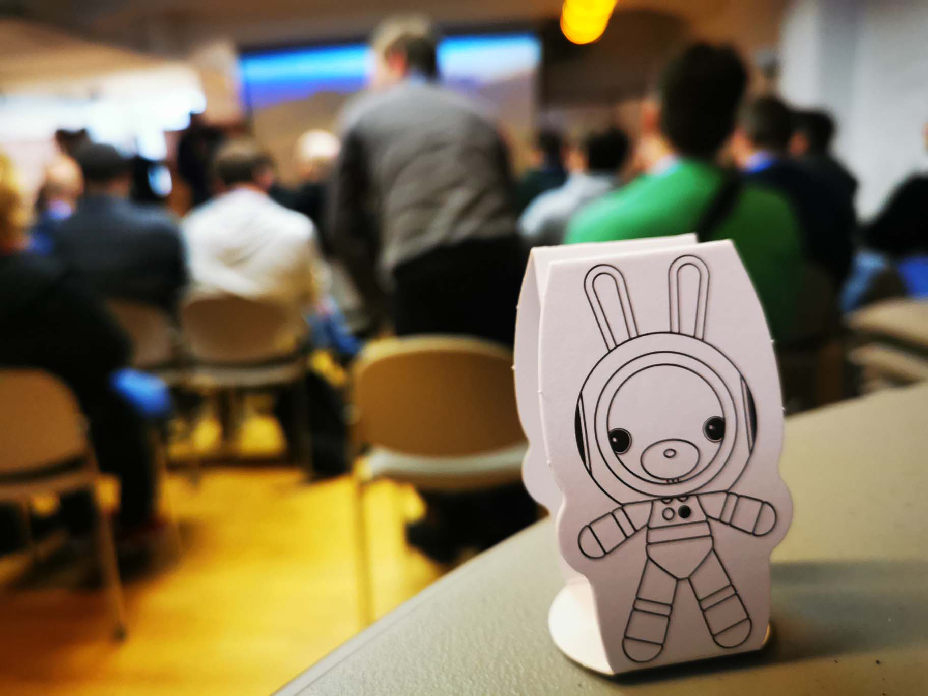 In front of the picture is a bunny in a spacesuit. The crowd in the background.