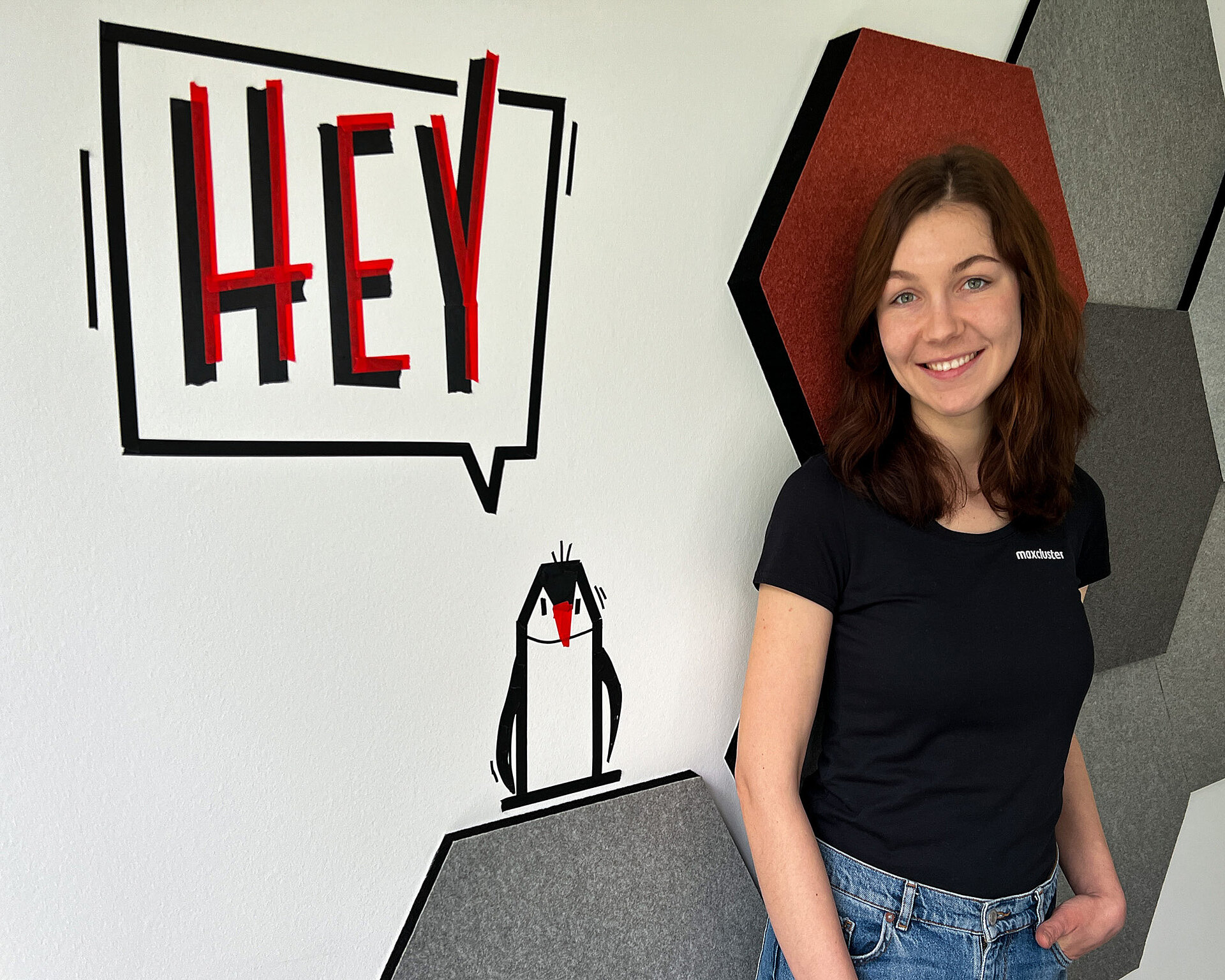 Julia Müseler vor einer Wand im maxcluster Büro.