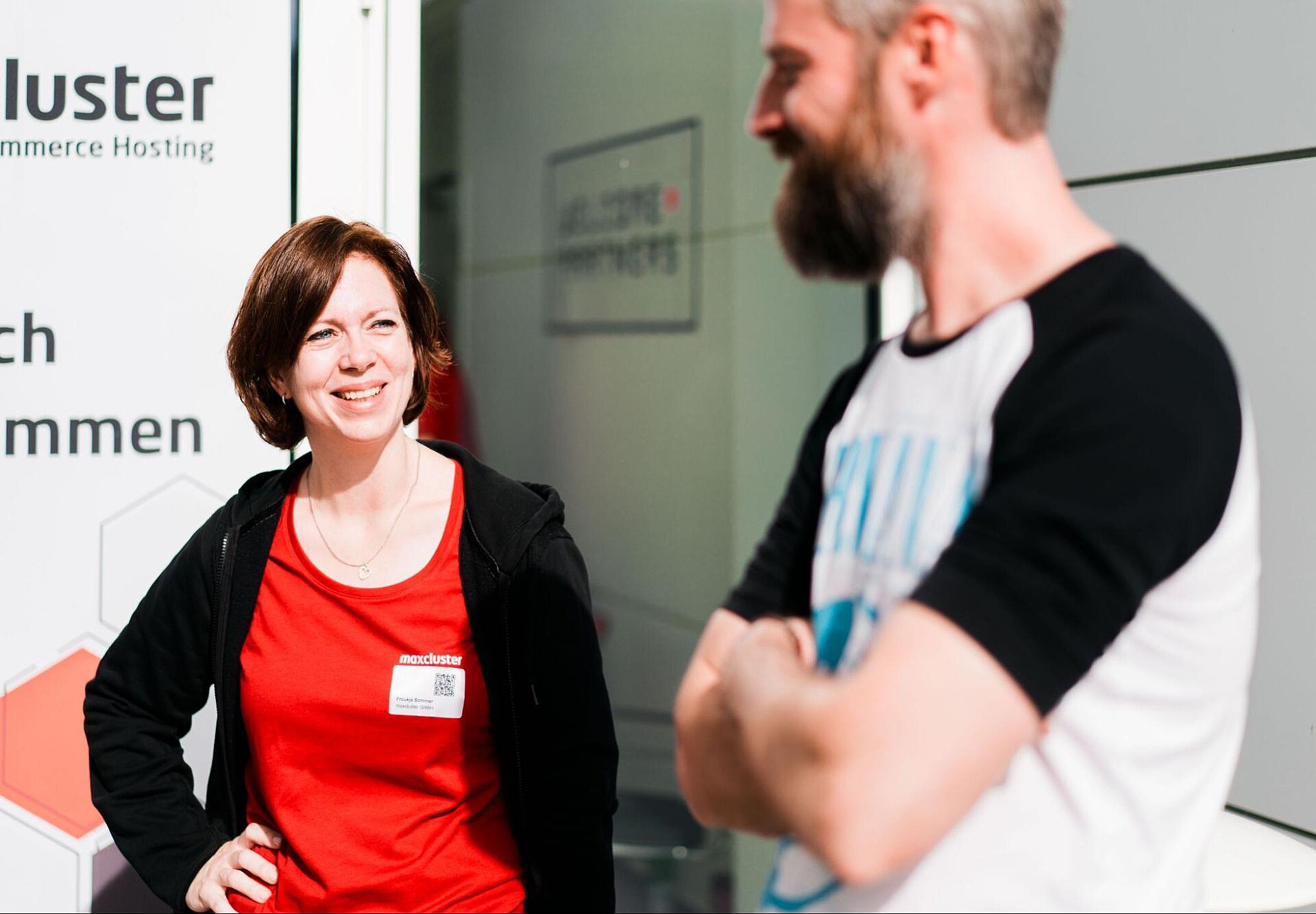 Zwei Personen im Gespräch vor dem maxcluster-Gebäude während des Partnertags 2025.