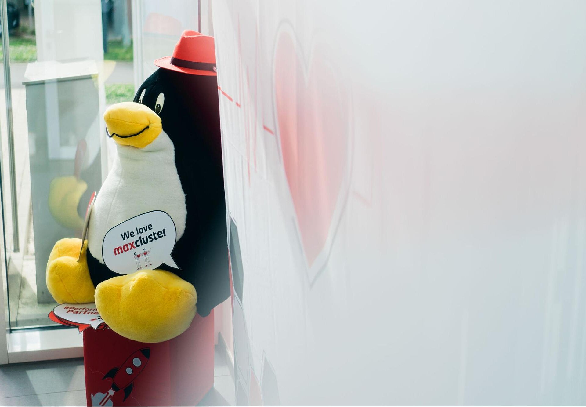Stoffpinguin mit dem Schriftzug „We love maxcluster“ im Eingangsbereich des maxcluster-Büros.
